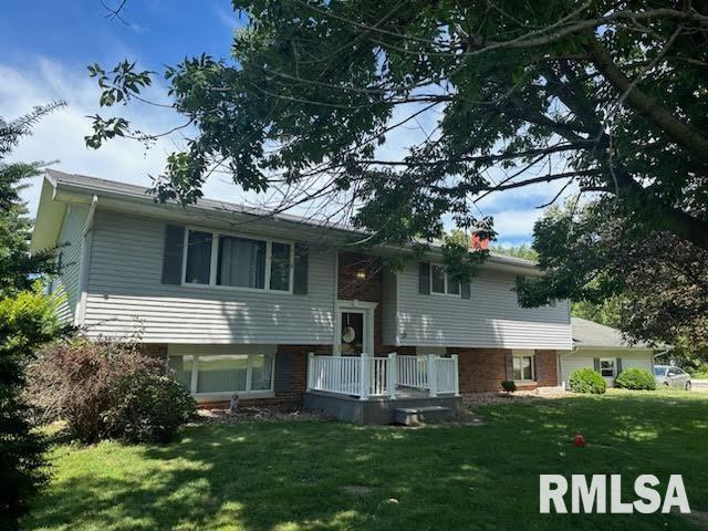 bi-level home featuring a front lawn and brick siding