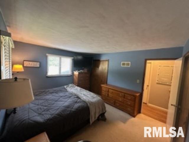 bedroom featuring a textured ceiling and wood-type flooring