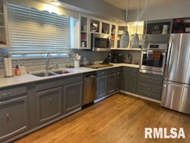 kitchen featuring light hardwood / wood-style flooring, sink, gray cabinets, and appliances with stainless steel finishes