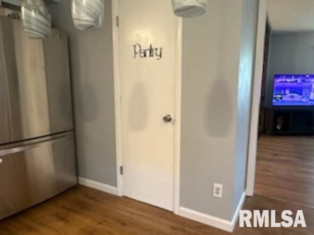 interior space featuring stainless steel refrigerator and wood-type flooring