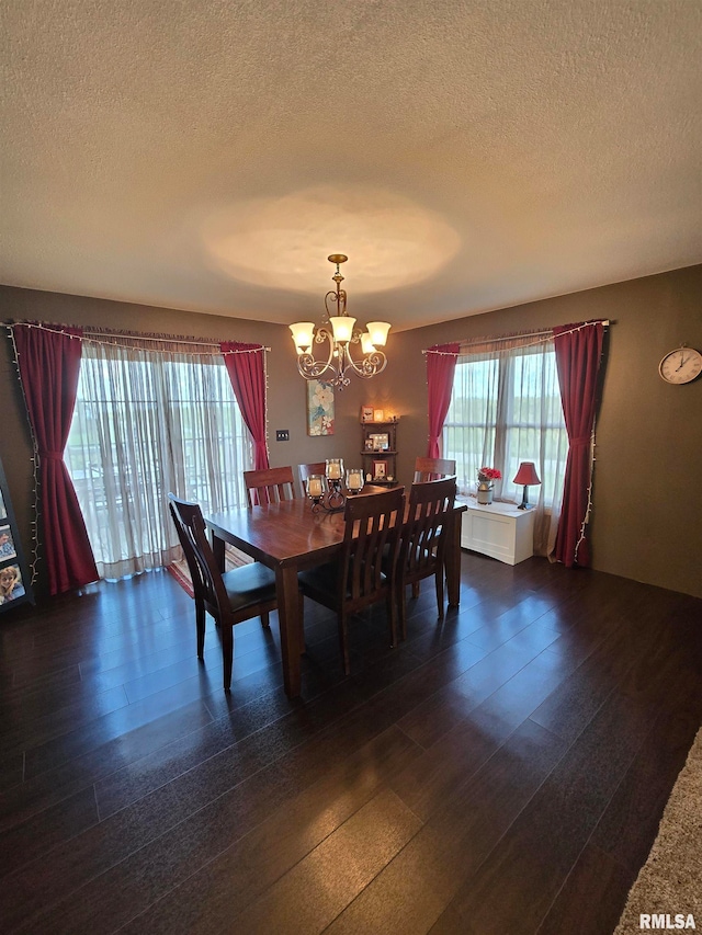 dining space featuring dark hardwood / wood-style floors, a chandelier, and a textured ceiling