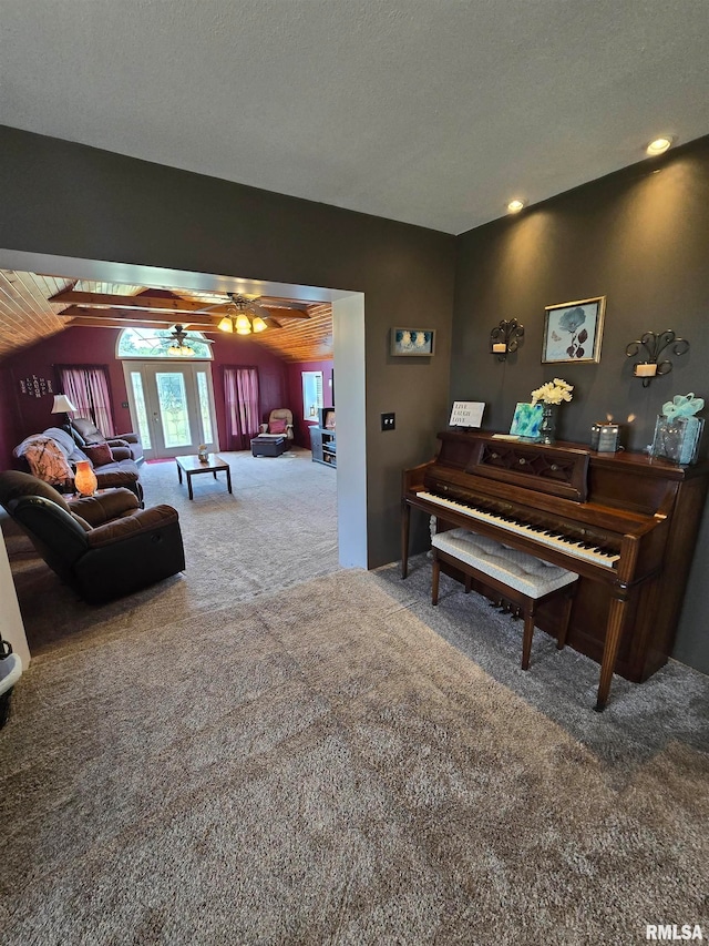 living room with a textured ceiling, carpet flooring, and ceiling fan