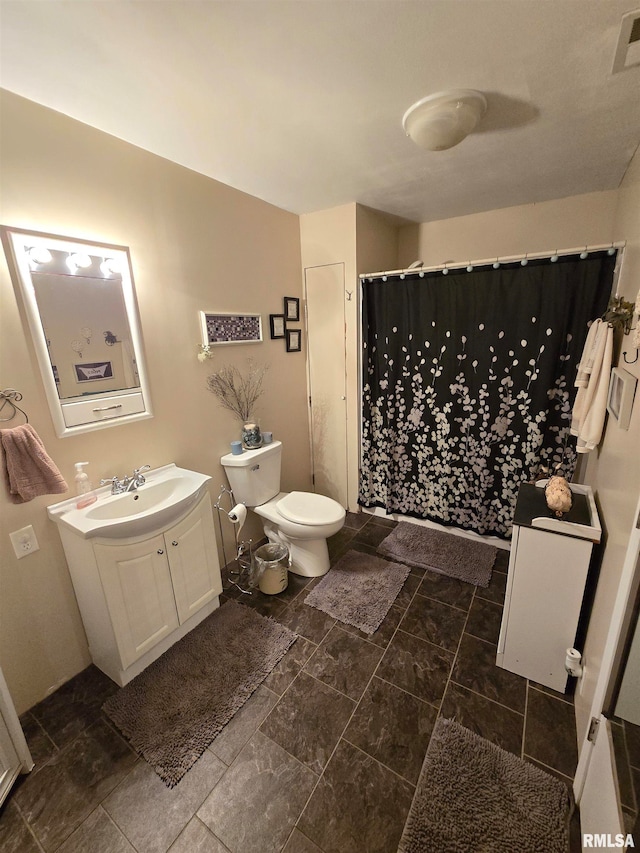 bathroom with curtained shower, toilet, and vanity