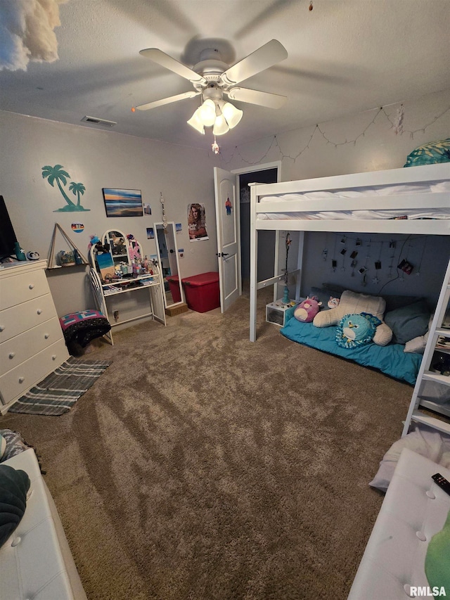 bedroom featuring a textured ceiling, carpet, and ceiling fan