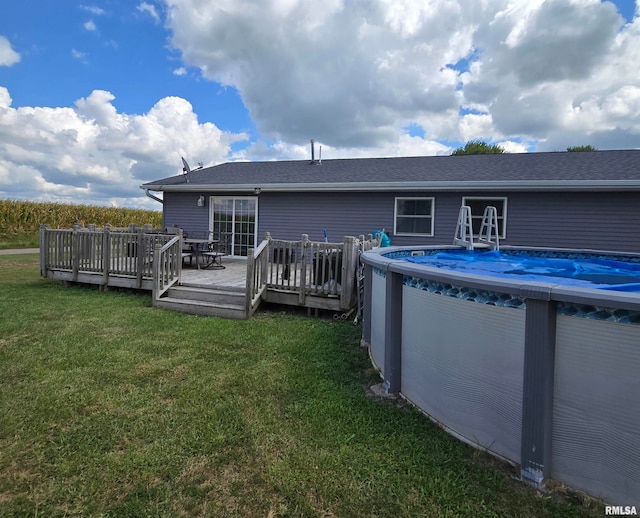 rear view of house with a yard and a pool side deck