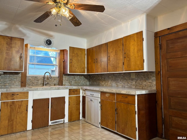 kitchen with ceiling fan, decorative backsplash, and sink