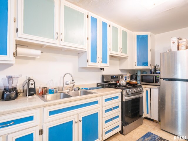 kitchen featuring white cabinets, light tile patterned floors, stainless steel appliances, and sink