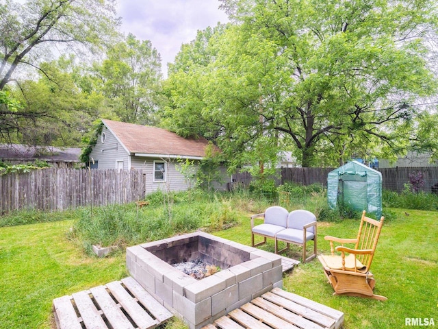 view of yard featuring a fire pit and a storage unit