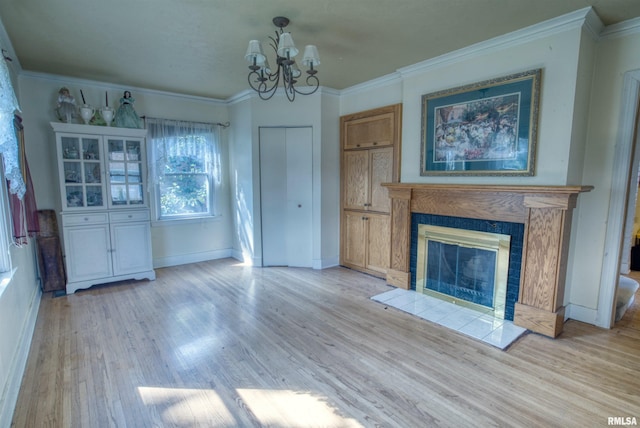 unfurnished living room featuring a fireplace, an inviting chandelier, ornamental molding, and light wood-type flooring