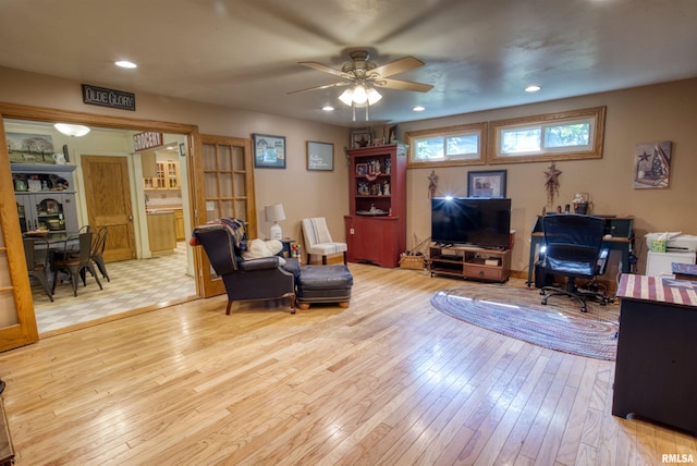 living room featuring ceiling fan and light wood-type flooring