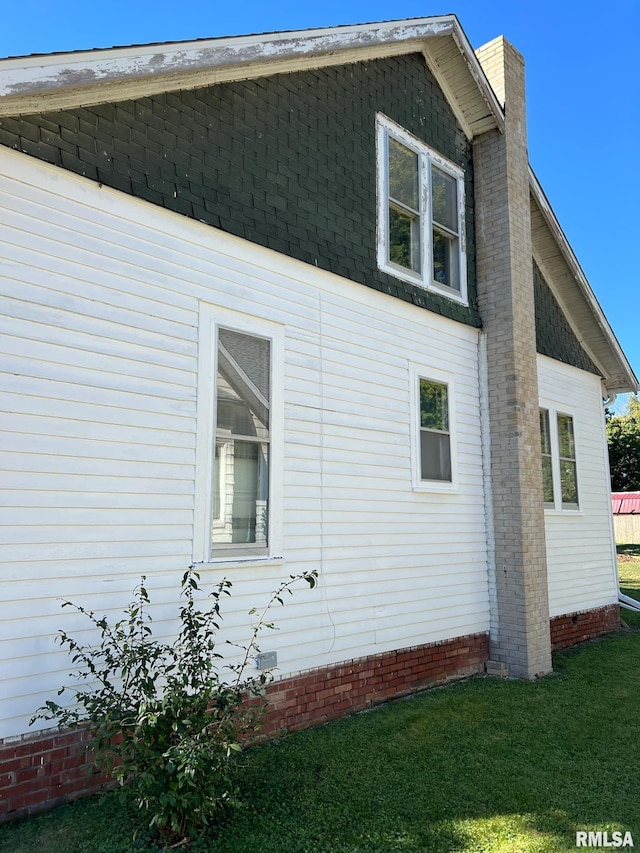 view of side of home with a lawn