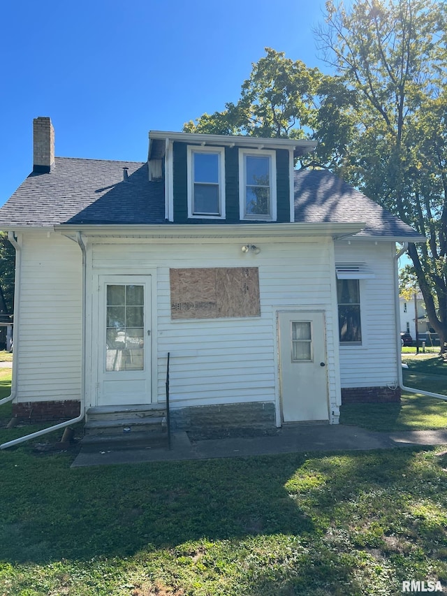 rear view of house featuring a lawn