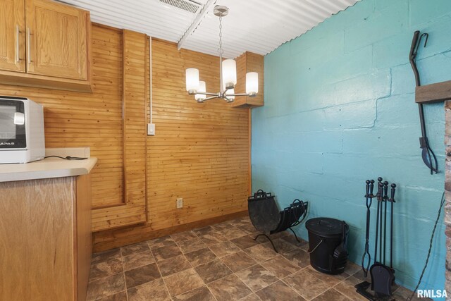 interior space with a notable chandelier and wooden walls