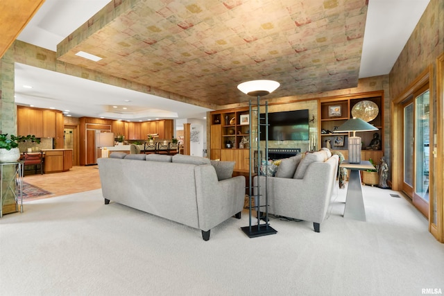 living room featuring a large fireplace and light colored carpet