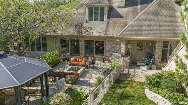 200 W Ravinwoods Rd, Peoria, IL 61615 - rear view of property featuring a patio area, outdoor lounge area, a shingled roof, and brick siding