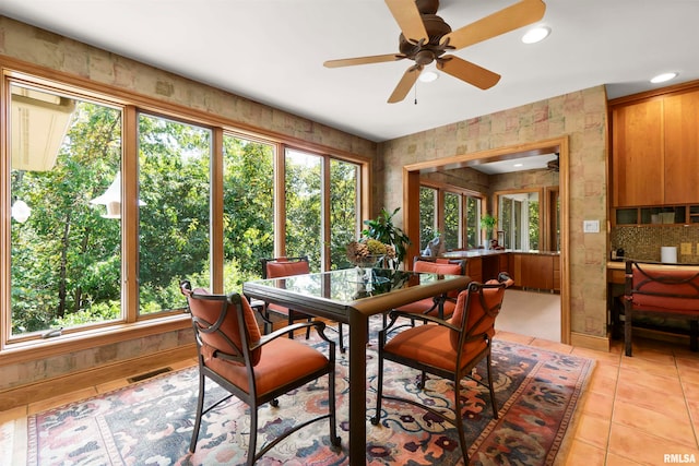 tiled dining space with ceiling fan and plenty of natural light