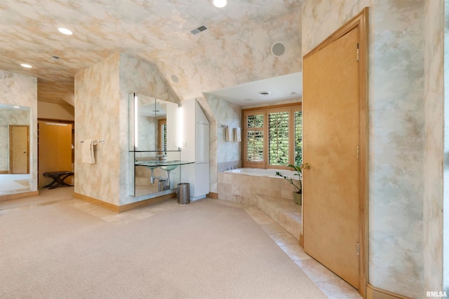 bathroom with vaulted ceiling and a tub