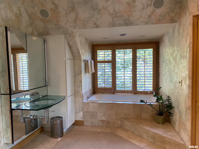 bathroom with tiled bath and tile patterned floors