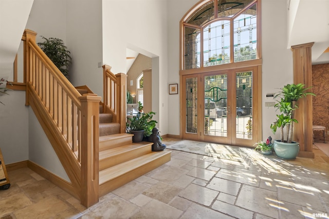 200 W Ravinwoods Rd, Peoria, IL 61615 - entrance foyer with a towering ceiling, stone tile flooring, stairs, baseboards, and french doors