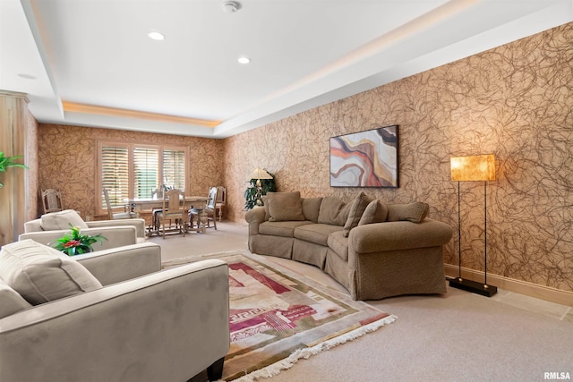 living room featuring a tray ceiling and carpet