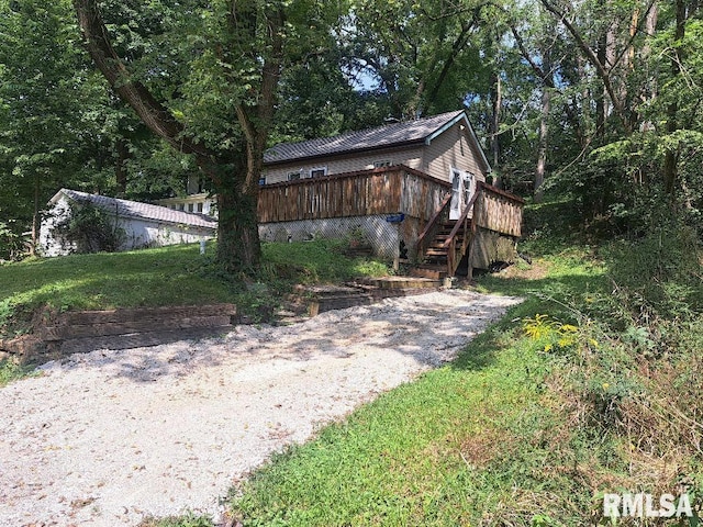 view of side of property with stairway and a wooden deck