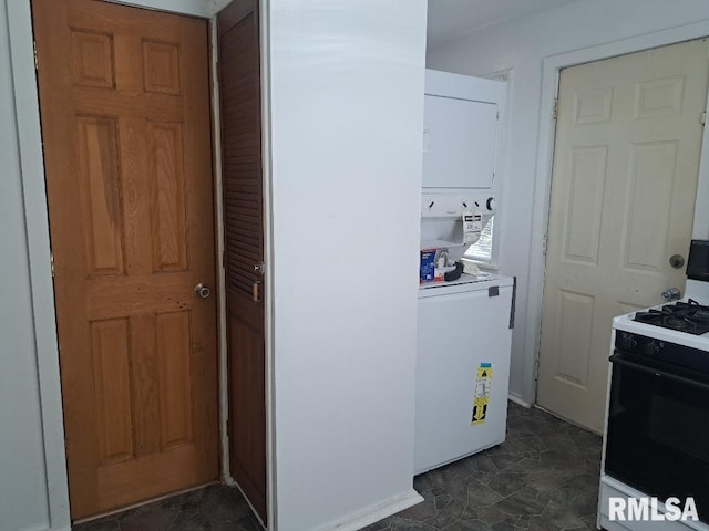 clothes washing area featuring laundry area and stacked washing maching and dryer