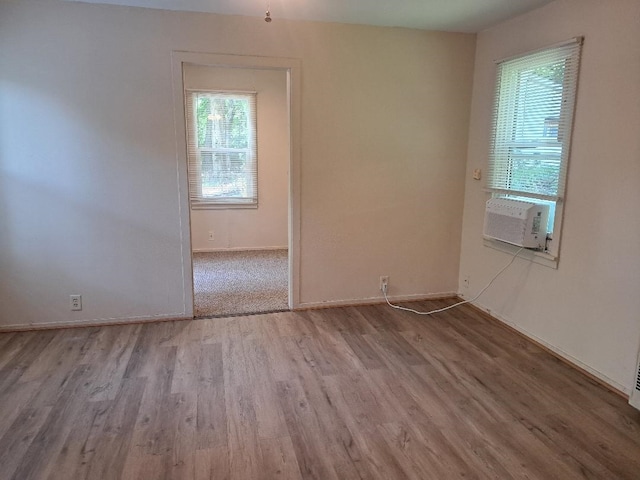 empty room featuring cooling unit, wood finished floors, and baseboards