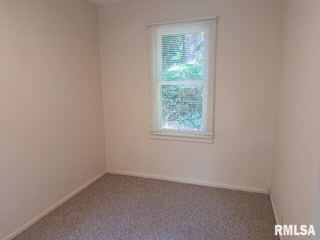 spare room with baseboards and carpet