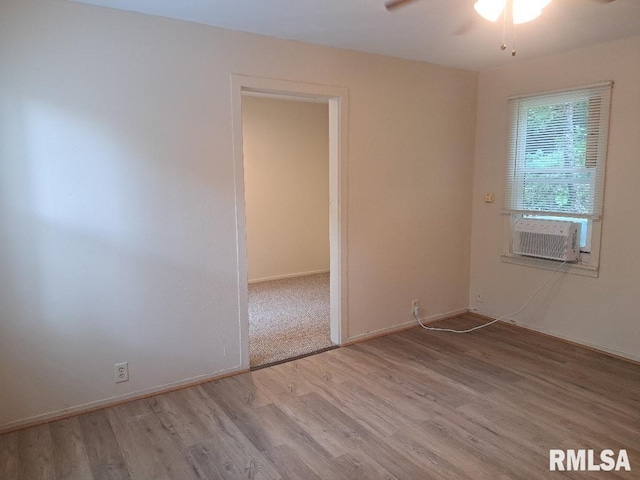 spare room featuring cooling unit, baseboards, ceiling fan, and wood finished floors