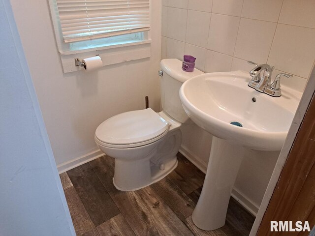 bathroom featuring tile walls, wood-type flooring, backsplash, sink, and toilet