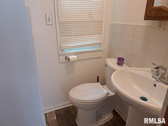 bathroom featuring a sink, toilet, tile walls, and wood finished floors