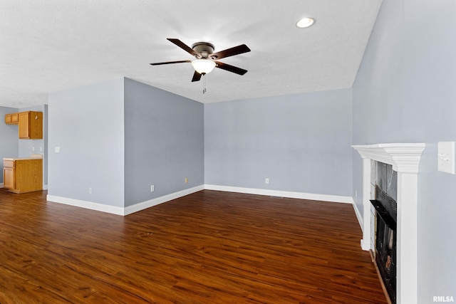 unfurnished living room with ceiling fan and dark wood-type flooring