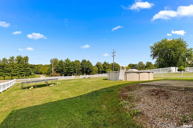 view of yard featuring a fenced in pool and a trampoline