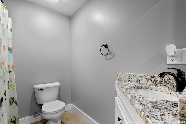 bathroom featuring toilet, tile patterned floors, and vanity