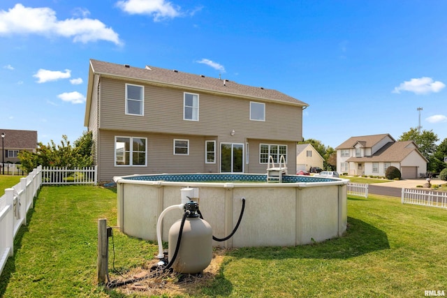 back of house featuring a lawn and a fenced in pool