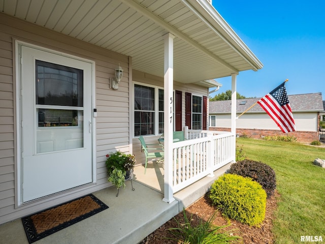 property entrance featuring a lawn and covered porch