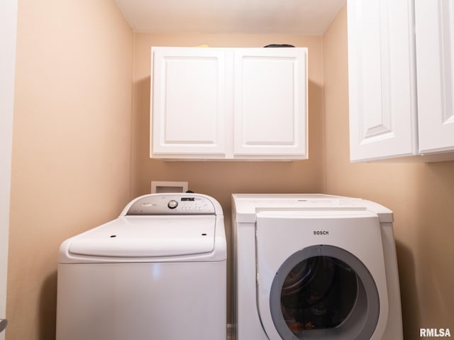 laundry area featuring cabinets and washer and clothes dryer