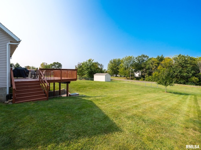 view of yard featuring a wooden deck and a shed