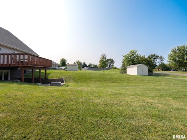 view of yard featuring a storage unit and a deck