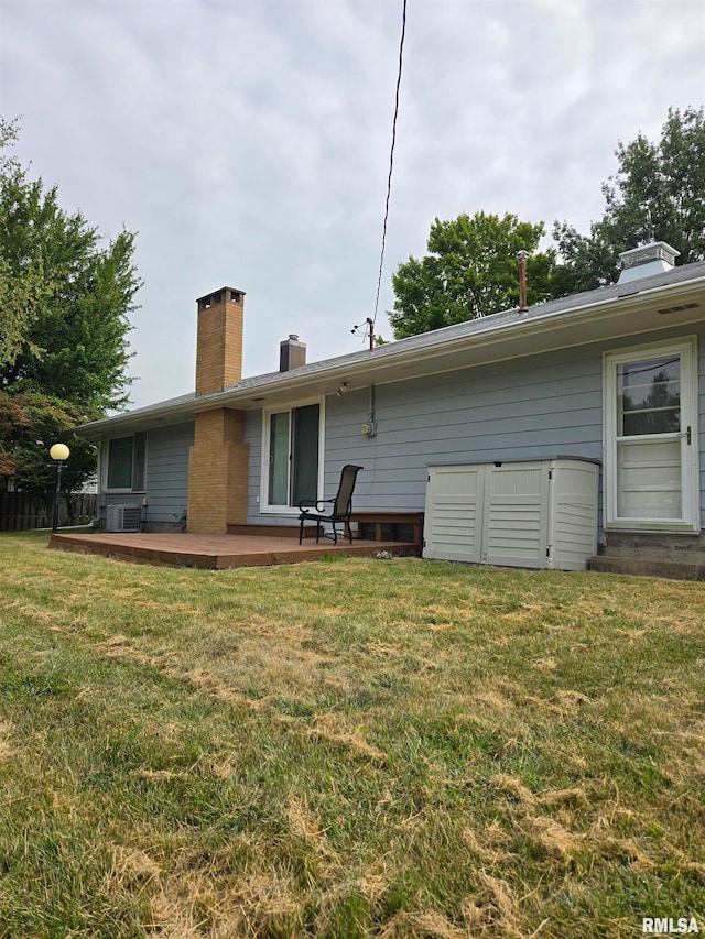 back of house with central air condition unit, a yard, and a patio