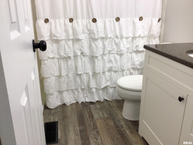 bathroom featuring toilet, hardwood / wood-style flooring, and vanity