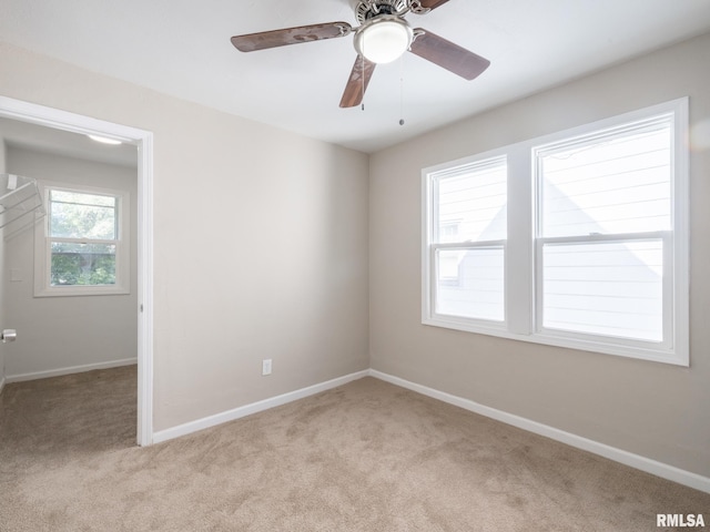 unfurnished room with ceiling fan and light colored carpet