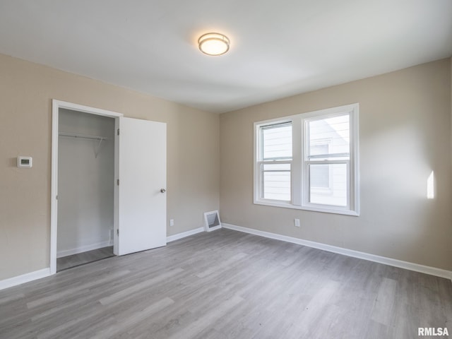 unfurnished bedroom with light hardwood / wood-style flooring and a closet