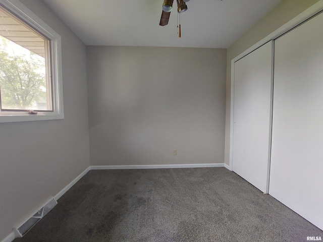 unfurnished bedroom with a closet, carpet, and ceiling fan