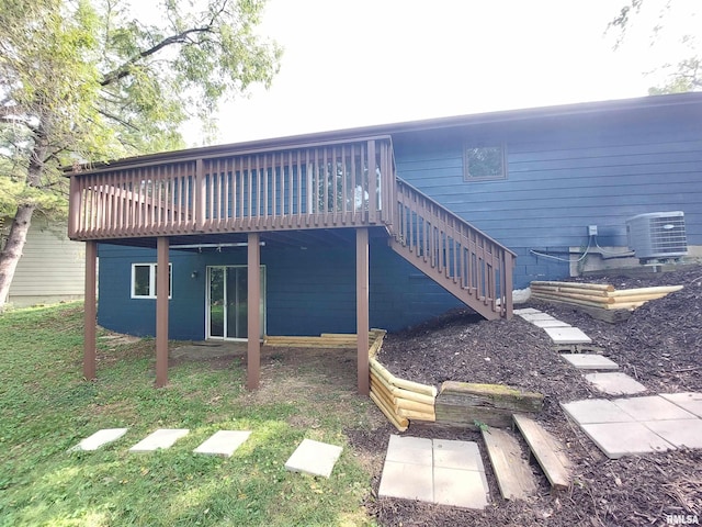 back of property with a wooden deck and central AC