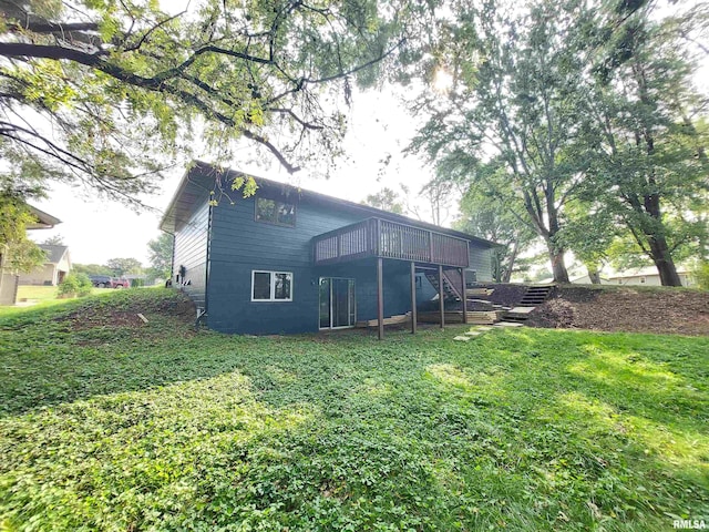 rear view of house featuring a lawn and a deck