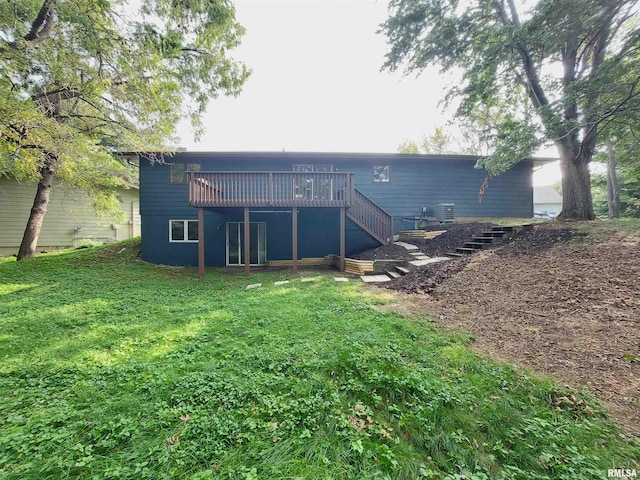 rear view of property featuring cooling unit, a deck, and a lawn