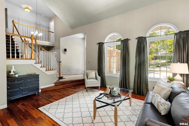 living room with a notable chandelier, a high ceiling, and dark wood-type flooring