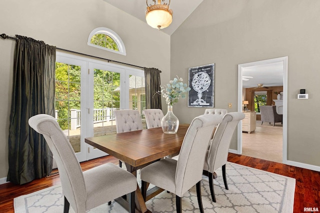 dining room with ceiling fan, high vaulted ceiling, french doors, and hardwood / wood-style flooring