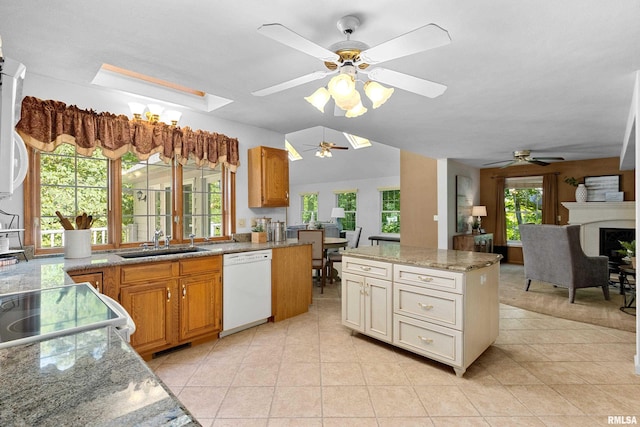 kitchen featuring ceiling fan, white dishwasher, sink, and a center island